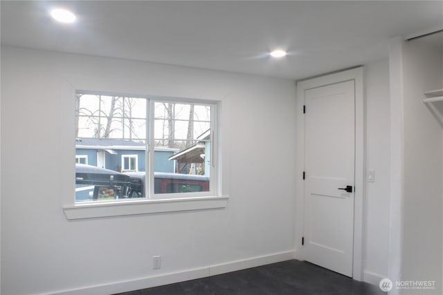 empty room with recessed lighting, dark wood finished floors, and baseboards