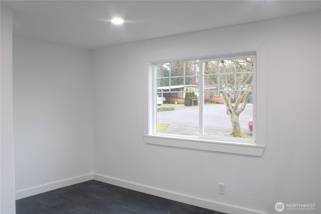 unfurnished room with baseboards