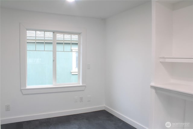 unfurnished room featuring dark wood-style floors and baseboards