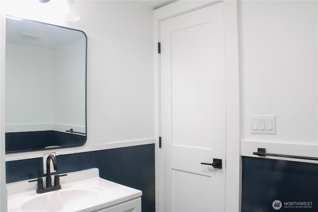 bathroom with a wainscoted wall and vanity