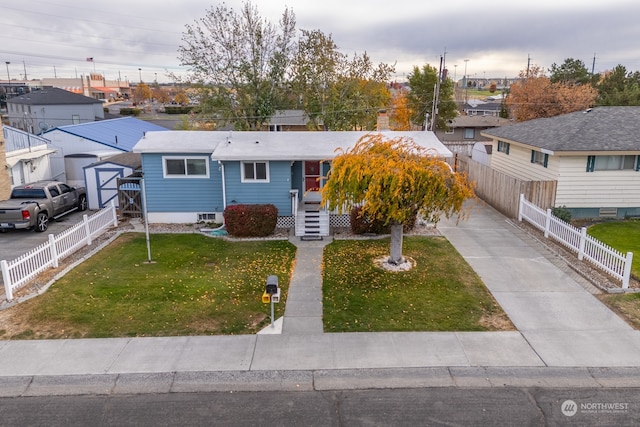 view of front of property with a storage unit and a front yard