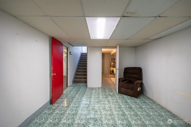 basement featuring a drop ceiling and carpet floors