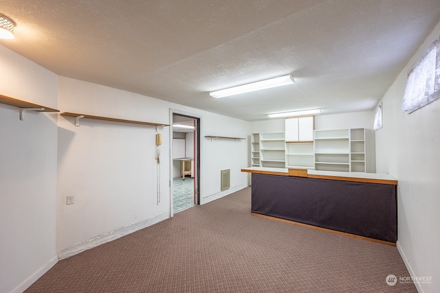 basement with carpet flooring and a textured ceiling