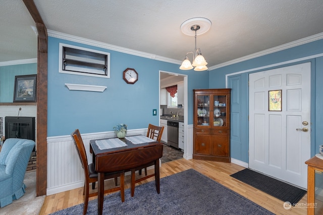 dining area with light wood-type flooring and ornamental molding