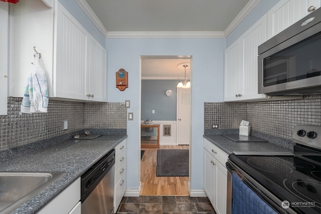 kitchen with dark hardwood / wood-style flooring, white cabinets, a notable chandelier, ornamental molding, and appliances with stainless steel finishes