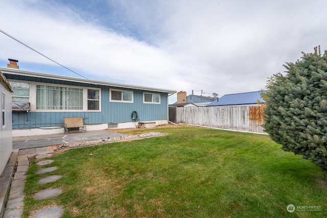 rear view of property featuring a patio and a lawn