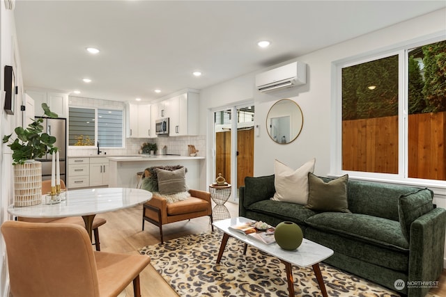 living room with light hardwood / wood-style floors, a wall mounted AC, and sink