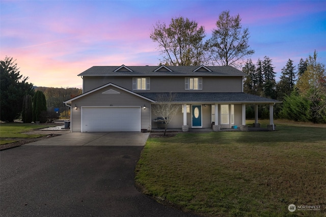 view of front of home featuring a porch, a garage, and a lawn