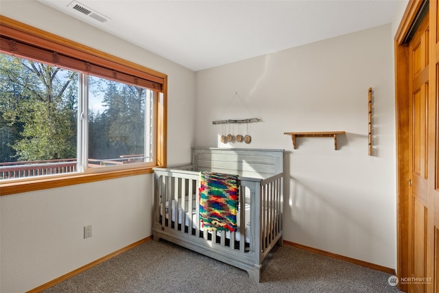 unfurnished bedroom with a closet, a crib, and carpet flooring