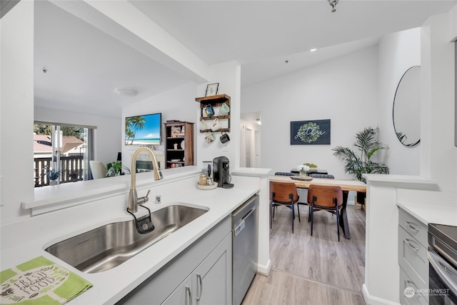 kitchen with gray cabinetry, light hardwood / wood-style floors, appliances with stainless steel finishes, and sink