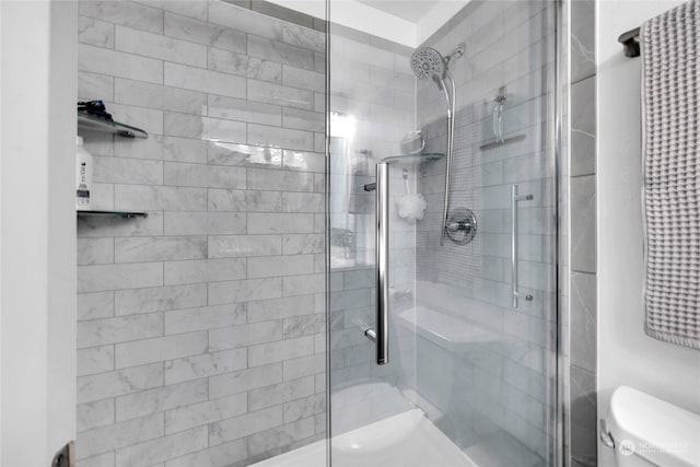 bathroom with toilet and a shower with shower door