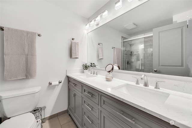 bathroom with toilet, a shower with shower door, vanity, and tile patterned floors