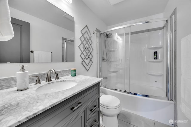 full bathroom featuring vanity, toilet, shower / bath combination with glass door, and tile patterned flooring