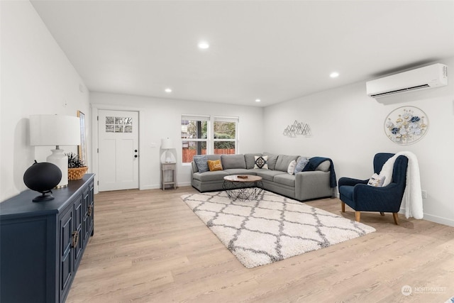 living room featuring light hardwood / wood-style flooring and a wall unit AC