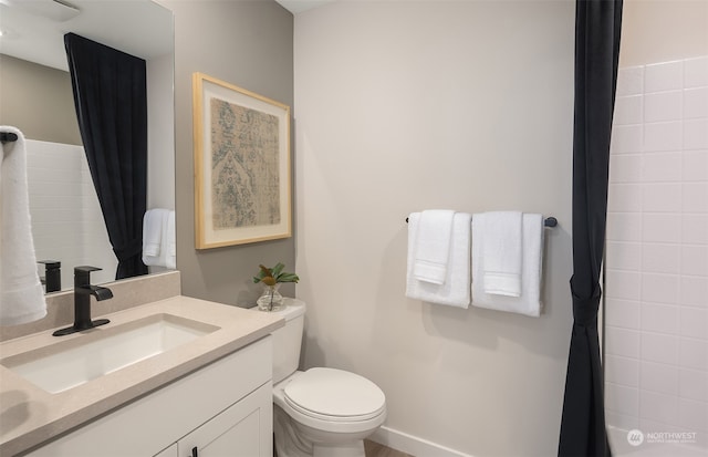 bathroom featuring toilet, walk in shower, and vanity