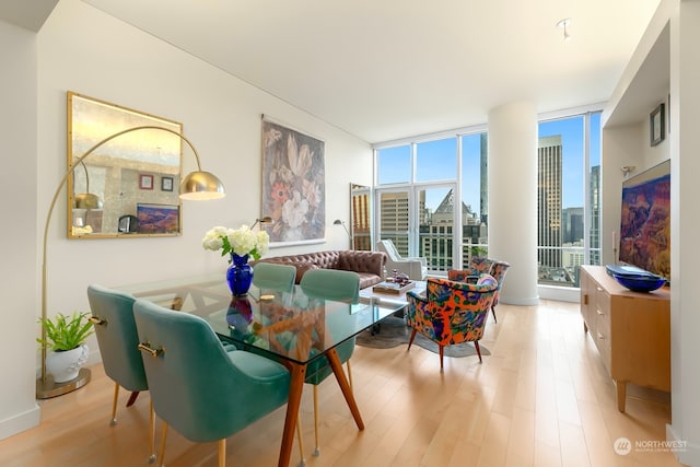 dining area with light hardwood / wood-style floors and expansive windows