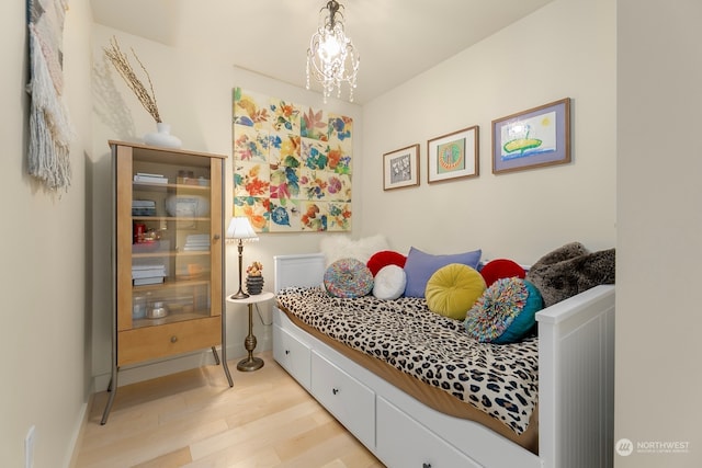 bedroom with a notable chandelier and light hardwood / wood-style floors