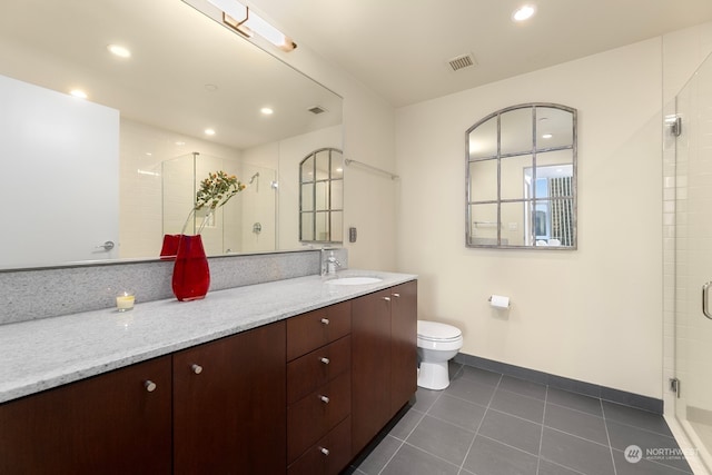 bathroom featuring vanity, walk in shower, toilet, and tile patterned floors