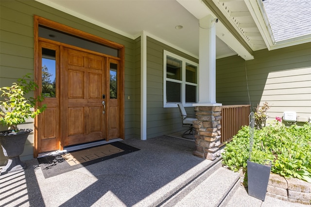 view of exterior entry featuring covered porch