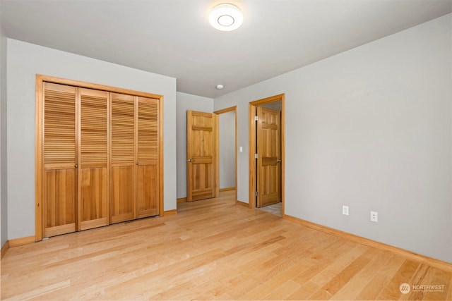 unfurnished bedroom featuring a closet and light wood-type flooring