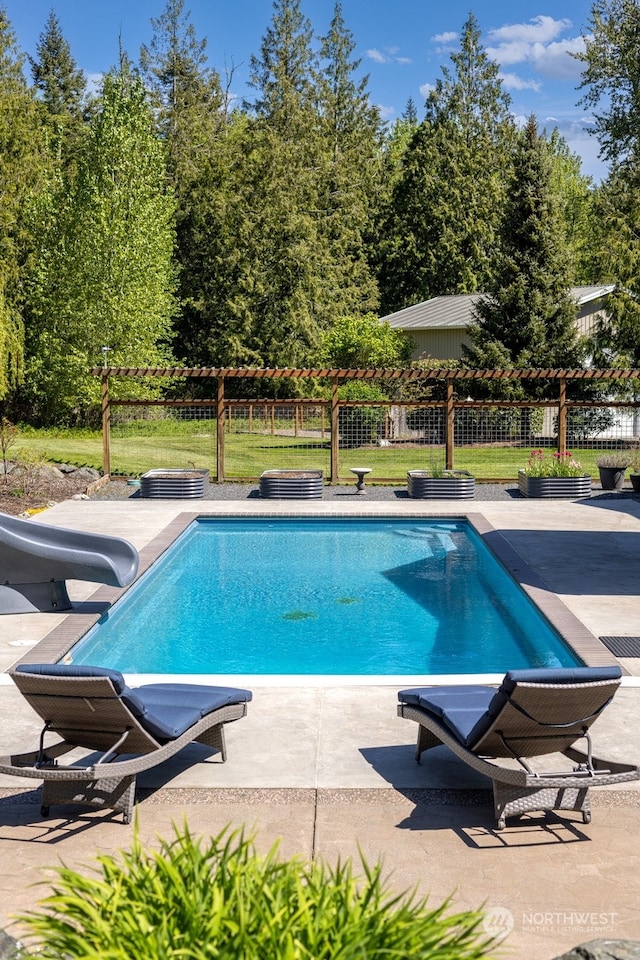 view of pool with a water slide and a patio area