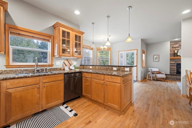 kitchen with stone countertops, decorative light fixtures, dishwasher, and sink