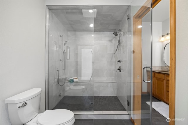 bathroom with vanity, tile patterned flooring, a shower with door, and toilet