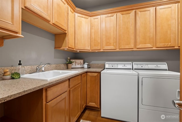 washroom featuring cabinets, sink, and washing machine and dryer