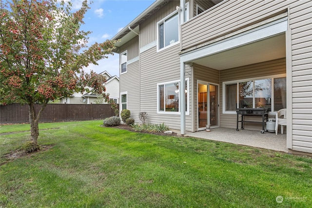 back of house featuring a patio and a lawn