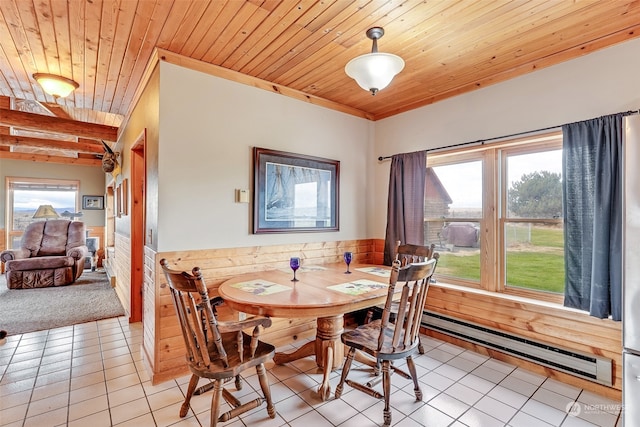 tiled dining space with wood ceiling, a baseboard heating unit, wood walls, and plenty of natural light