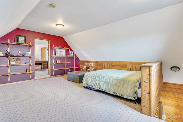 bedroom featuring hardwood / wood-style flooring and vaulted ceiling