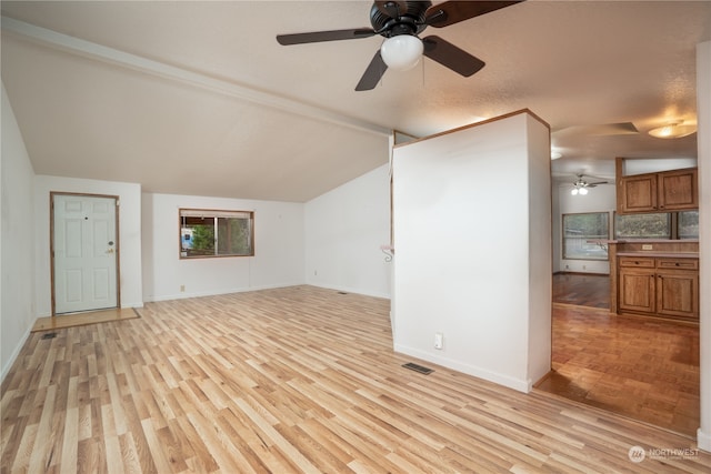 unfurnished living room featuring vaulted ceiling with beams, ceiling fan, light hardwood / wood-style flooring, and a textured ceiling