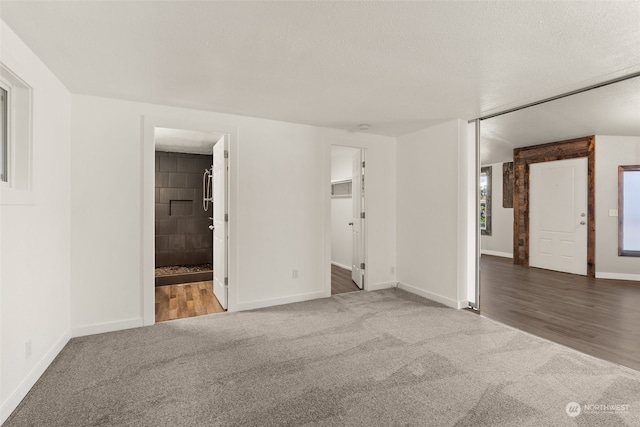 unfurnished room featuring wood-type flooring and a textured ceiling