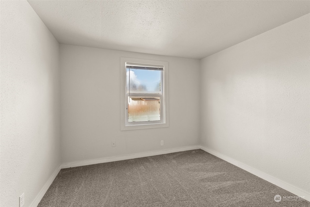 carpeted spare room with a textured ceiling