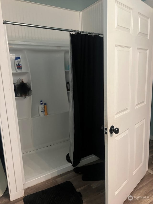 bathroom with hardwood / wood-style flooring and curtained shower