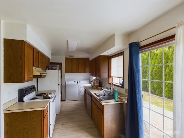 kitchen featuring white electric range, washer and dryer, plenty of natural light, and light hardwood / wood-style floors