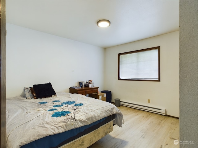 bedroom featuring baseboard heating and light hardwood / wood-style floors