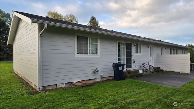 back of property featuring a patio area and a lawn