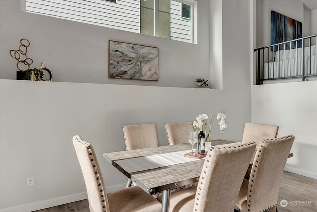 dining space featuring baseboards and wood finished floors