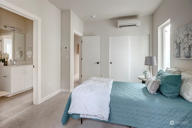 bedroom with light carpet, a closet, baseboards, an AC wall unit, and a sink