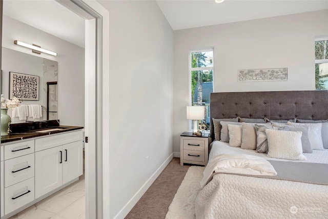 bedroom featuring ensuite bathroom and sink