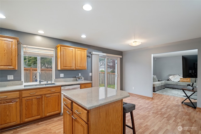 kitchen with light hardwood / wood-style flooring, a center island, sink, and plenty of natural light