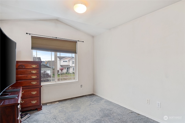 unfurnished bedroom featuring lofted ceiling and carpet