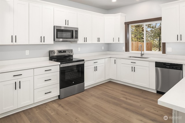 kitchen featuring dark wood-type flooring, appliances with stainless steel finishes, and white cabinets