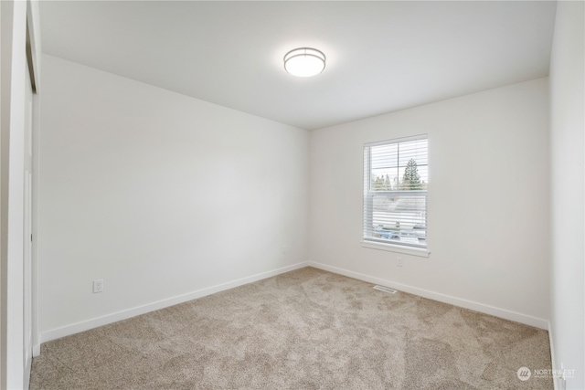 unfurnished room featuring light carpet