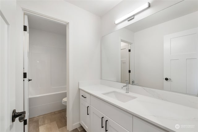 full bathroom with vanity, toilet, hardwood / wood-style flooring, and shower / bathtub combination