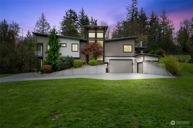 view of front facade featuring a yard, a balcony, and a garage