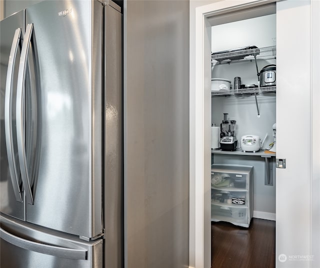 interior space featuring stainless steel fridge and dark hardwood / wood-style floors