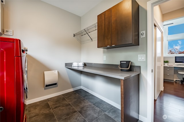 washroom with washer / dryer, dark hardwood / wood-style floors, and cabinets