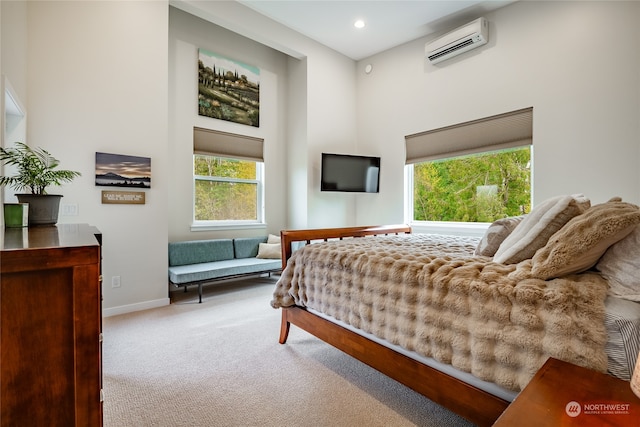 bedroom featuring an AC wall unit and light carpet